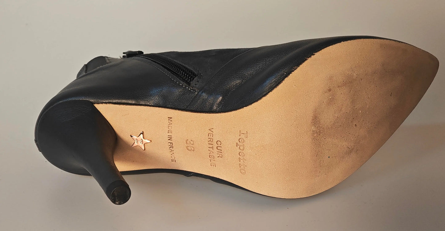 Bottines en cuir noir de Repetto avec fermeture éclair latérale et étoile décorative sur la semelle.
