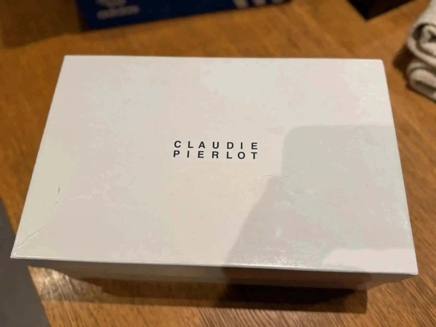 Boîte blanche de rangement de chaussures par Claudie Pierlot avec lettrage noir.
