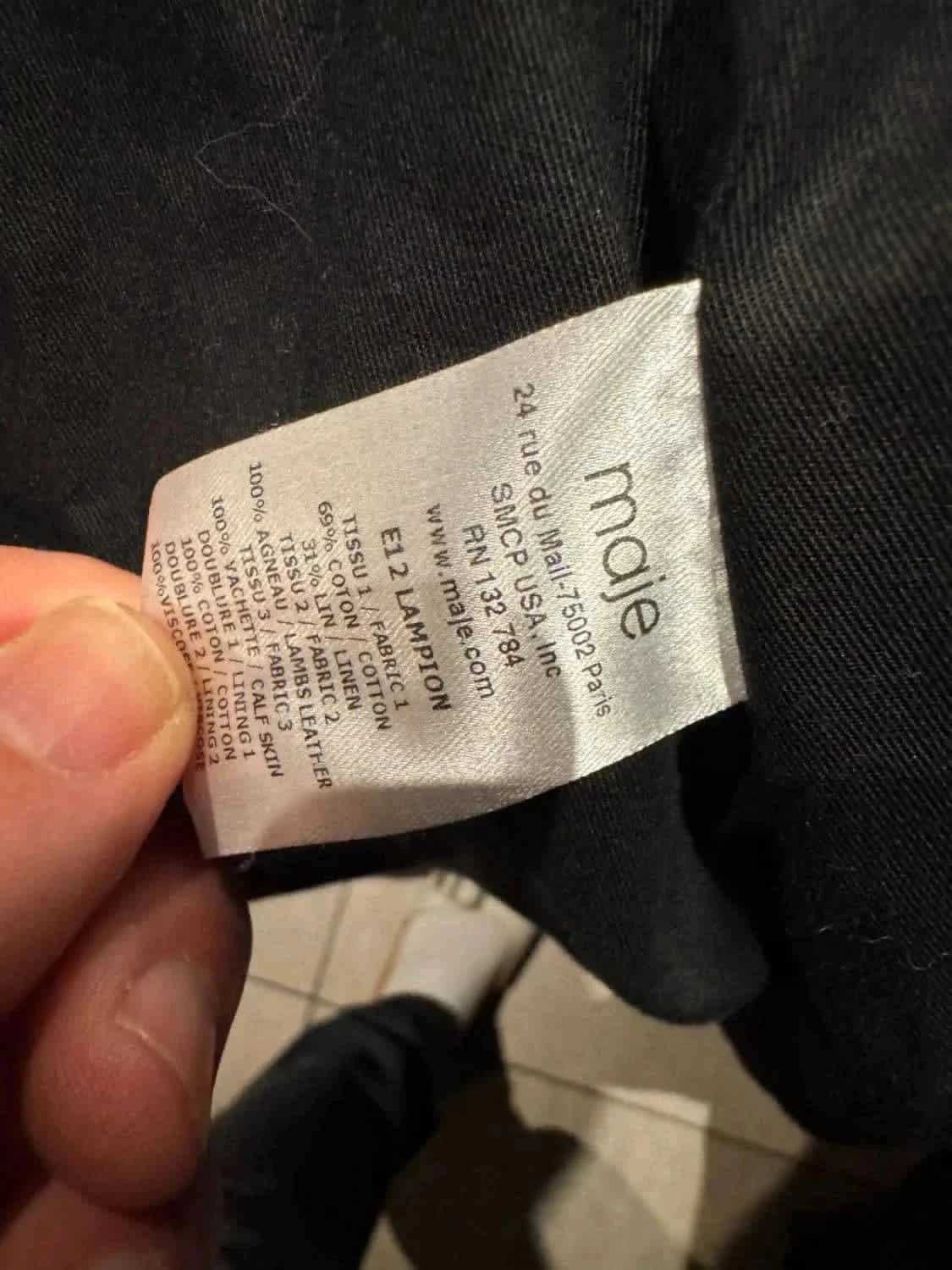Étiquette de composition du manteau Lampton de Maje, indiquant les matières utilisées pour sa fabrication.
