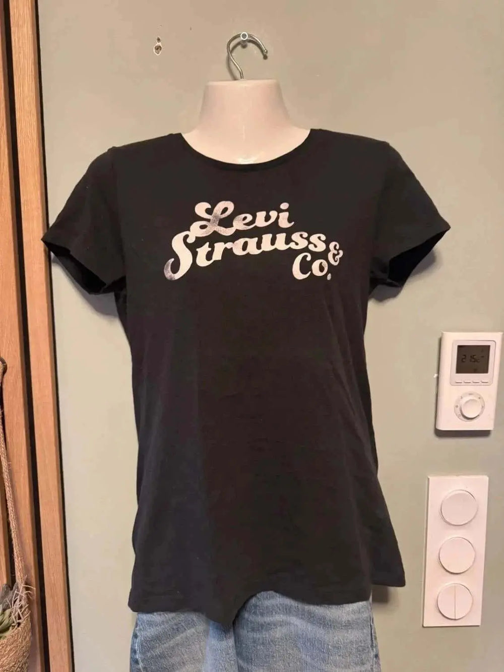 T-shirt noir à logo vintage de Levi's sur un mannequin, porté avec un jean.

