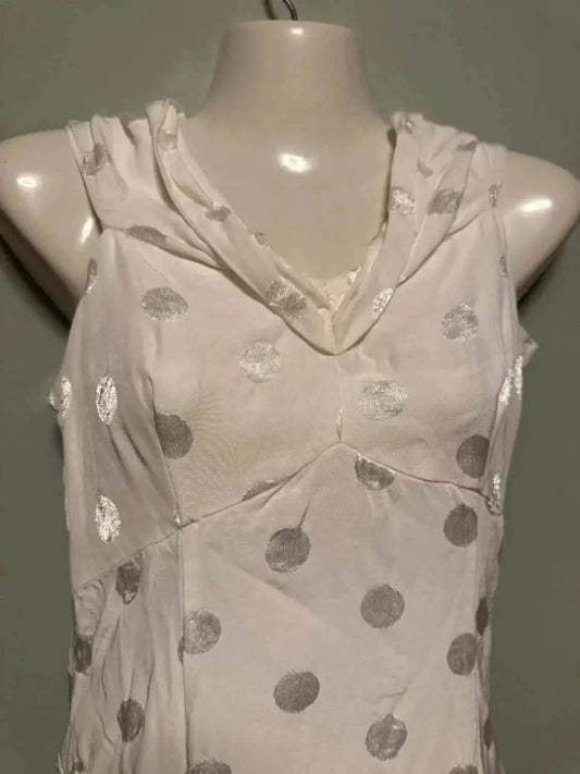 Robe blanche à pois argentés de NAF NAF, drapée au col, sur mannequin.