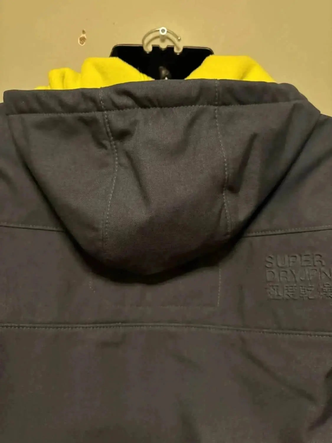 Veste Windtrekker grise de Superdry, avec capuche et détails de couture.
