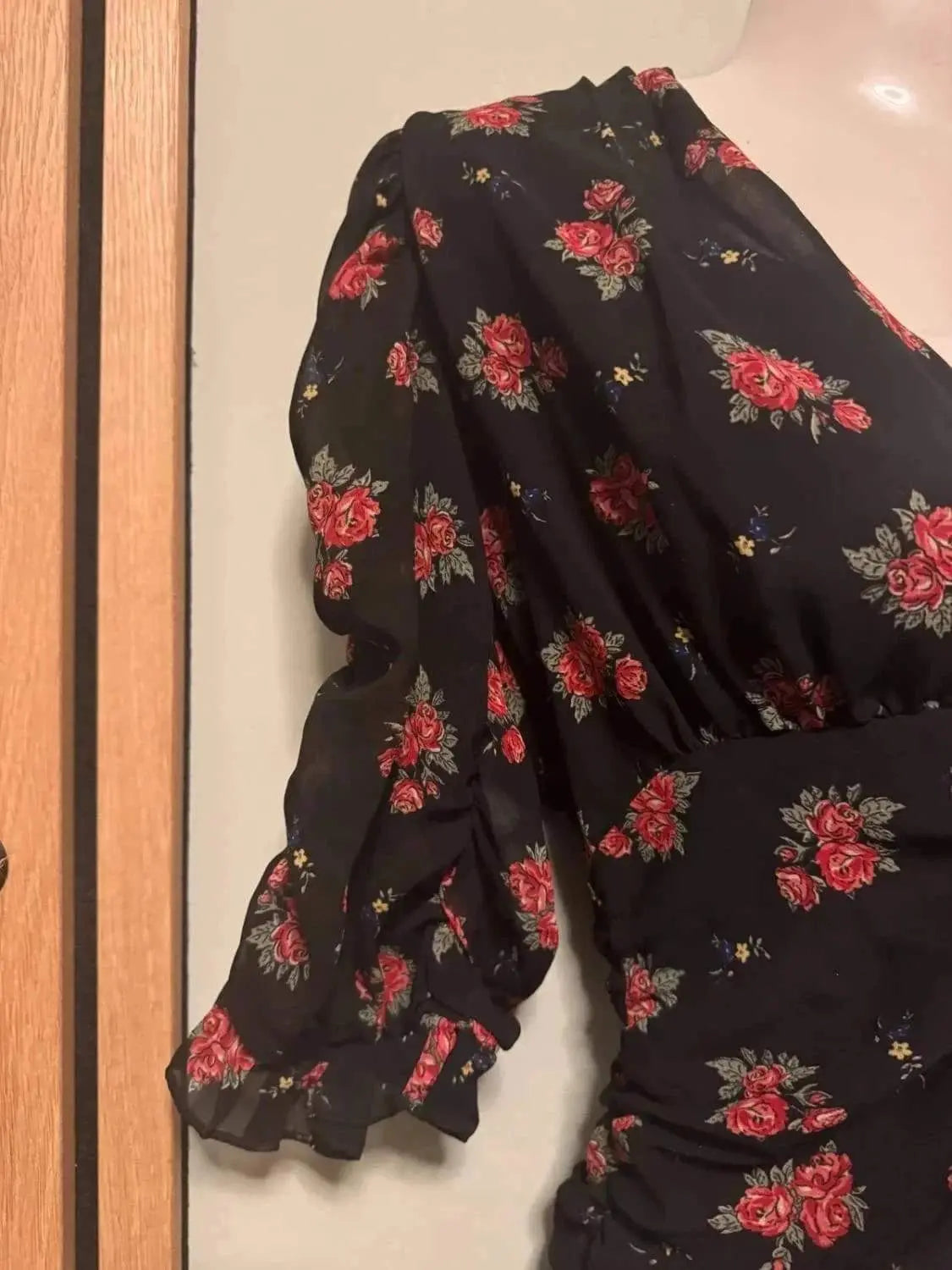 Robe Zara noire à fleurs, de seconde main Zara, avec manches bouffantes et ourlet à volants.
