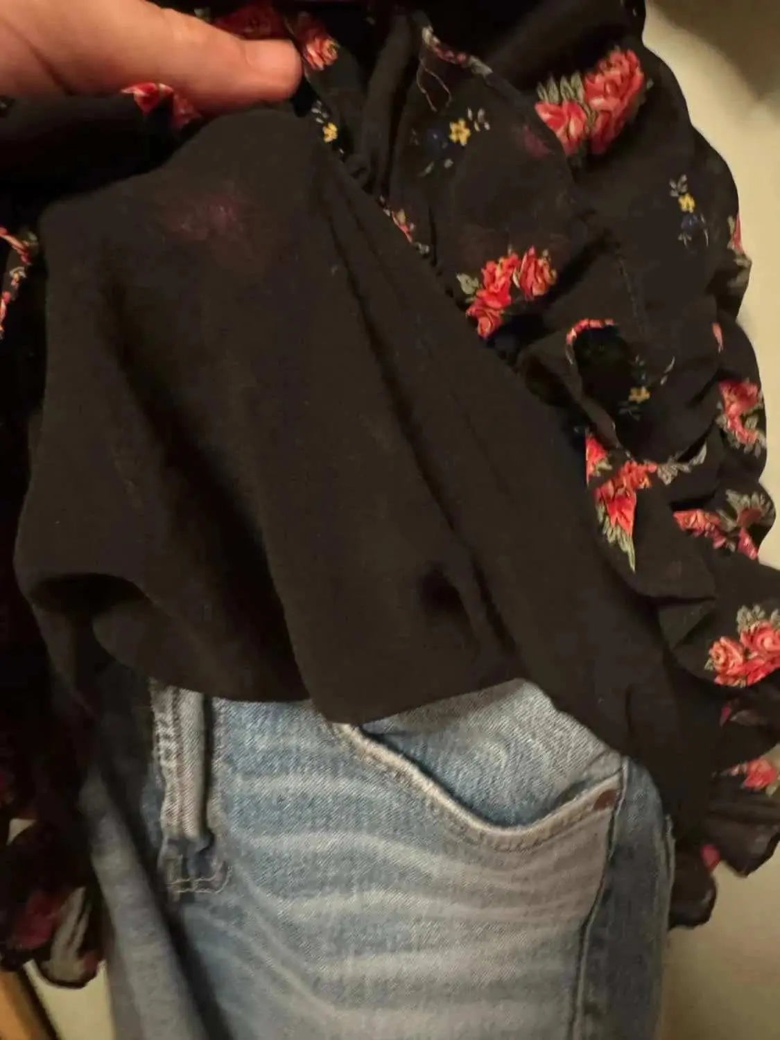 Robe Zara noire à fleurs, de Zara, avec doublure noire et détails à volants, portée avec un jean bleu clair.
