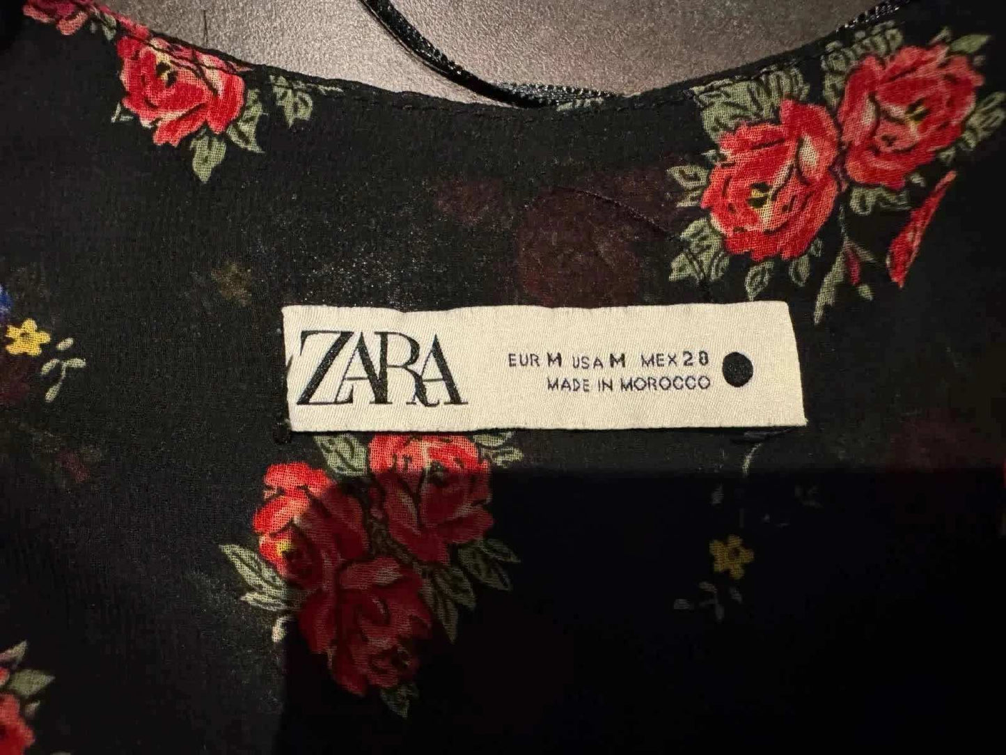 Robe noire à fleurs de Zara, avec un motif de roses rouges et de feuilles vertes.