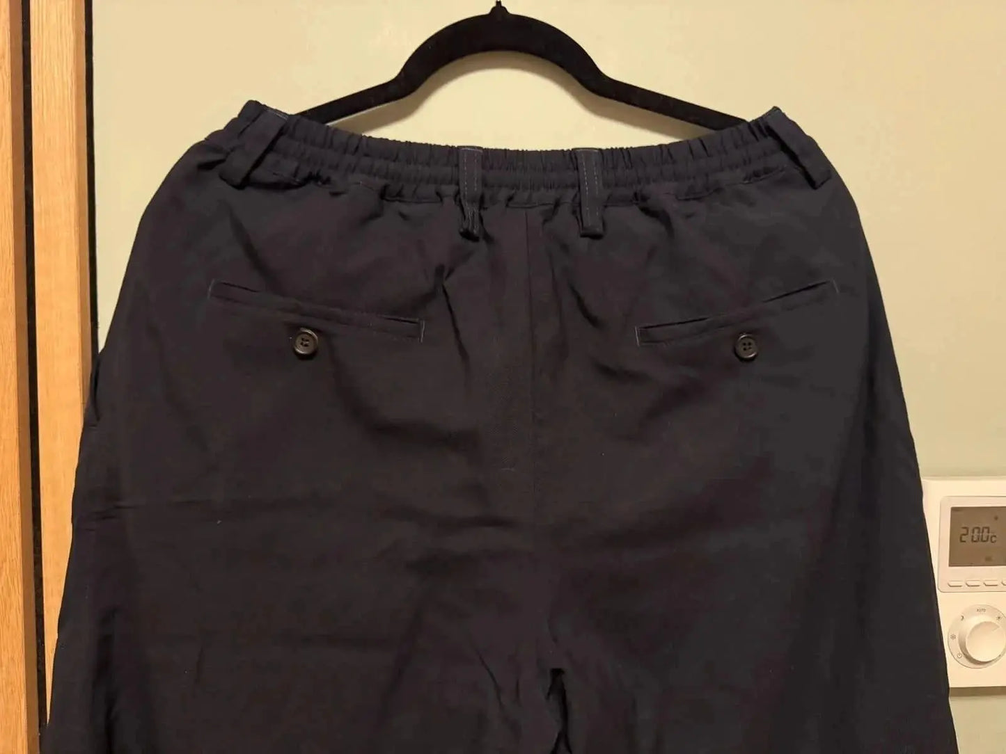 Pantalon noir ample de Marni, avec élastique à la taille et poches arrière boutonnées.
