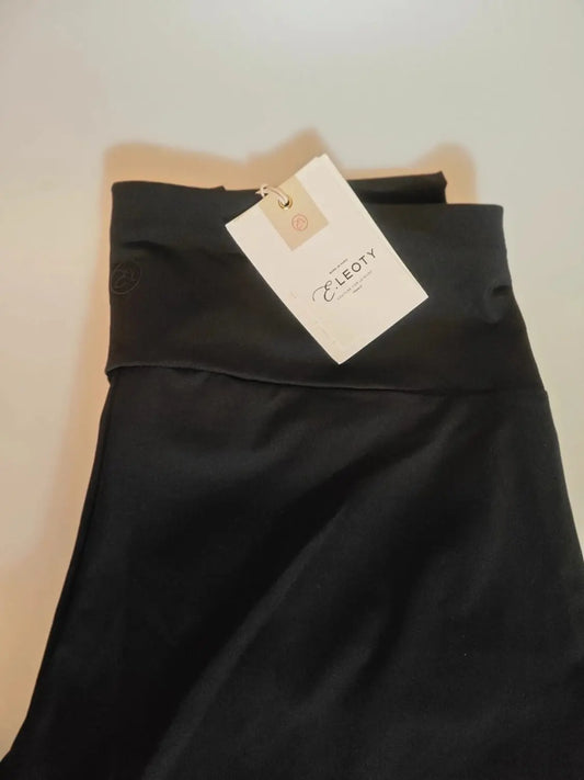 Legging noir, taille haute par Leoty, avec une étiquette blanche attachée.
