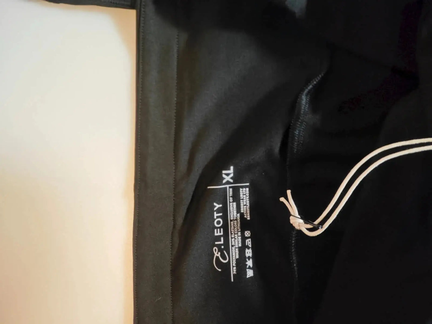 Legging noir de sport par Leoty, avec cordon de serrage et étiquette de taille XL visible.